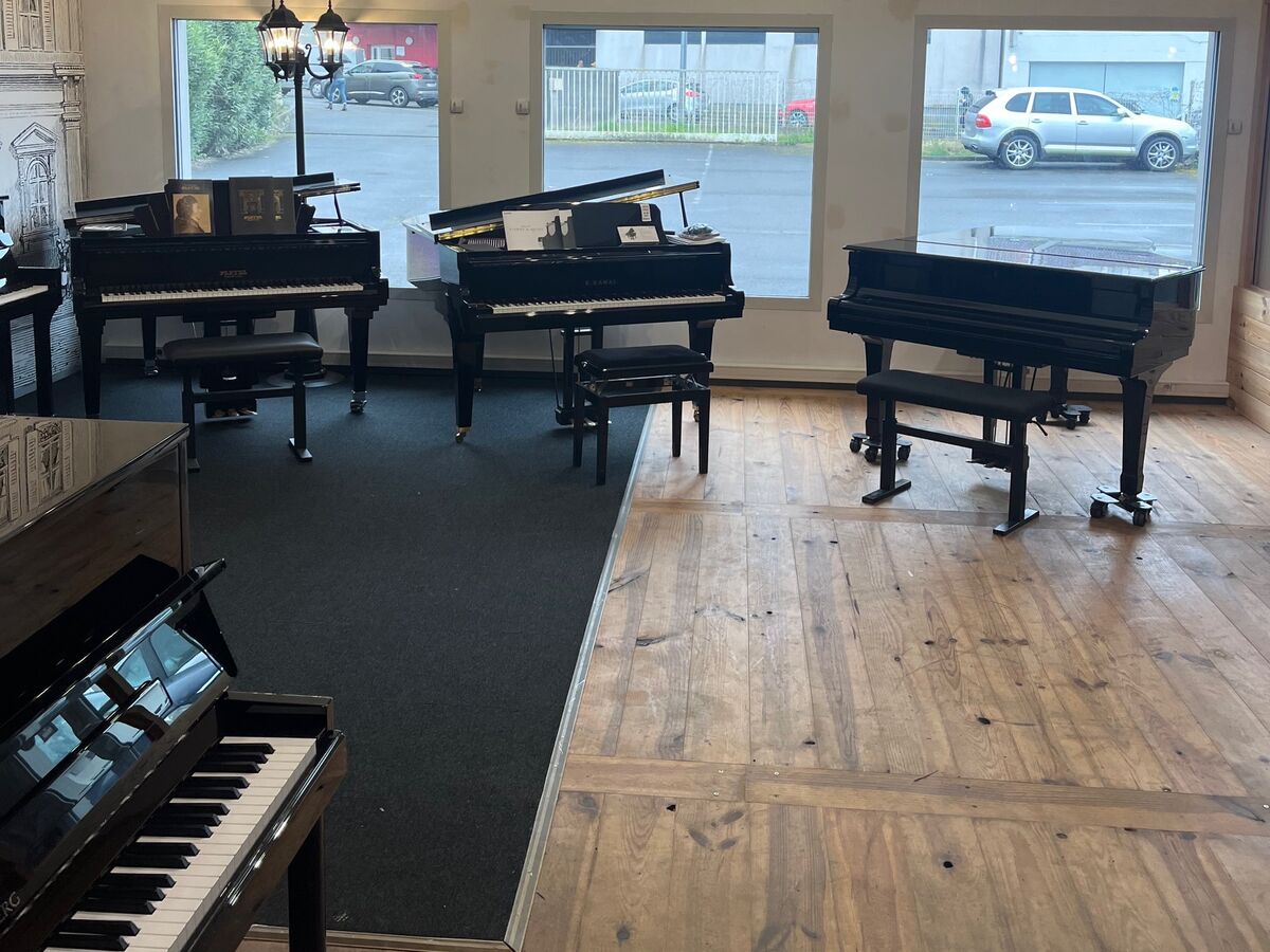 Trois pianos à queue exposés devant les fenêtres du magasin Ubico Musique à Dax